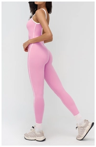 Side view of pink yoga jumpsuit with white contrast piping and body-hugging elastic fit