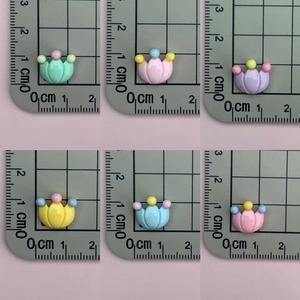 Mini crown-shaped resin charms in pastel colors on a ruler showing 1.2cm size