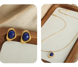 Detail of gold triangle necklace and earrings set with inlaid navy blue natural stone