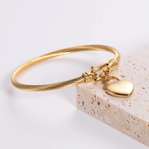 18k gold plated stainless steel 3mm cable wire bangle with heart charm on travertine