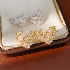 Gros plan de boucles d'oreilles cœur en or et argent avec zircons sur boîte à bijoux