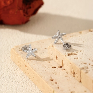 S925 sterling silver starfish earrings with white pearls on a textured stone surface