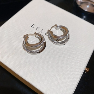 Detailed close-up of double-hoop silver earrings with pave-set cubic zirconia stones