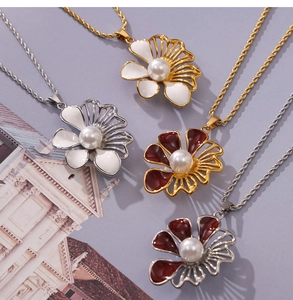 Dettaglio dei ciondoli a fiore vintage con perle su catene a corda in oro e argento