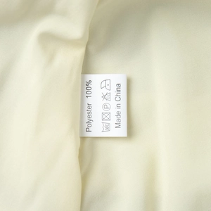 Macro view of a 100% polyester care label with washing instructions on a chiffon dress