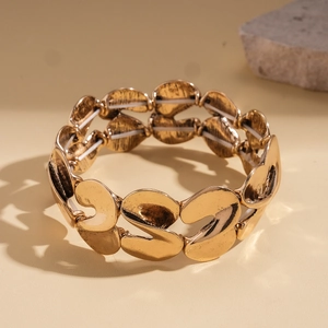 Detailed view of wide gold distorted link bracelet with textured finish and elastic cord