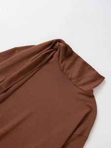 Close-up of the twisted turtleneck design on a brown knit sweater with soft texture