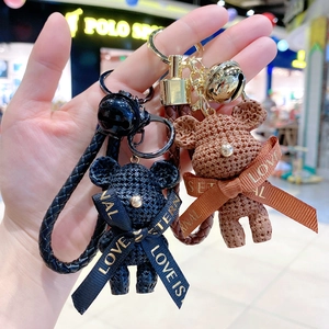 Detailed view of resin teddy bears with knit texture and Love is Eternal ribbons
