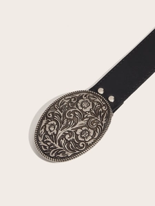 Detail of vintage black leather belt featuring a large floral engraved silver buckle