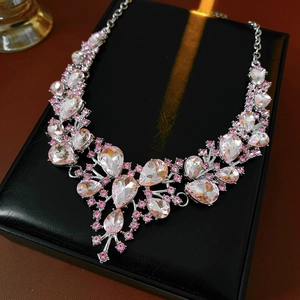 Detail of vintage style necklace featuring pink and clear teardrop crystals on black box