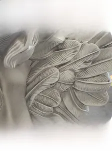 Close-up of vintage resin angel feather sculpture with distressed texture and antique finish