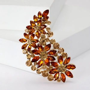 Macro shot of vintage gold flower brooch featuring amber crystal and rhinestone details