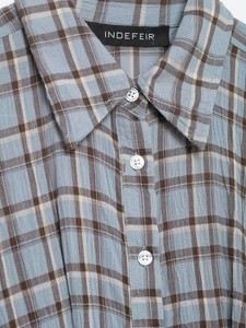 Detail of light blue plaid shirt collar with brown stripes and white resin buttons