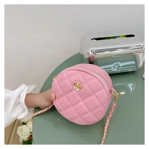 Detail of pink quilted round bag with gold flower ornament and metal chain strap