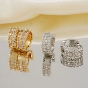 Minimalistische Klappcreolen in Gold und Silber mit Zirkonia-Besatz auf Satin-Hintergrund
