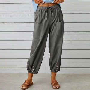 Dettaglio dei pantaloni in cotone e lino grigio scuro con tasche ampie e orli a bottoni