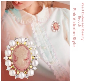 Macro detail of Victorian cameo brooch with pink silhouette and pearl border accents