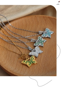 Détail de pendentifs papillons colorés en émail avec chaînes en acier titane or et argent