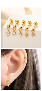 Detail of five golden titanium earrings featuring waterdrop and star-shaped zircon pendants