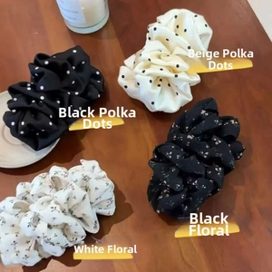 Detailed set of four floral and polka dot scrunchies on a warm wooden background