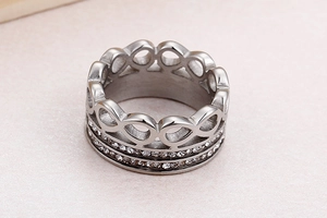 Macro shot of silver titanium steel crown ring with double-row crystals and infinity symbol
