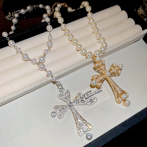 Detailed shot of vintage cross pendants with diamonds and pearls on a jewelry tray