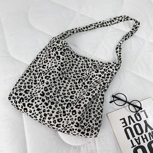 Detailed fabric texture of leopard print corduroy tote bag with fashion accessories