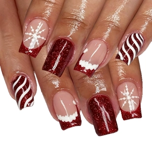 Unghie finte quadrate natalizie con glitter rossi, fiocchi di neve e design candy cane