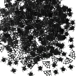 Macro shot of black plastic spider and cobweb confetti for Halloween party decor