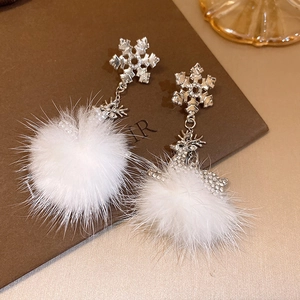 Detail of Christmas snowflake earrings with crystal reindeer and white faux fur pom poms