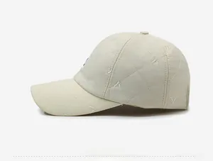 Side view of beige quilted baseball cap with detailed embroidery and diamond stitching