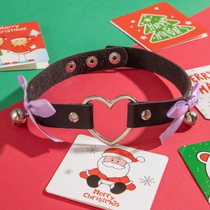 Gothic black leather choker with heart ring, purple bows and bells on festive background