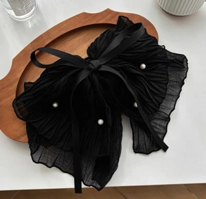 Detailed close-up of large black chiffon bow hair claw with elegant white pearls
