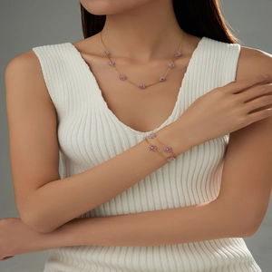 Detailed view of elegant purple flower necklace and bracelet set on a female model
