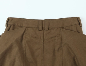 Detailed macro view of high-waist belt loops and twill texture on brown cargo skirt