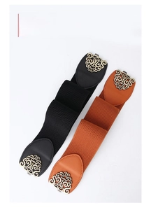 Close-up of vintage engraved metal buckles on black and brown elastic waist belts