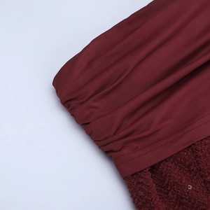 Détail de robe à paillettes bordeaux avec texture plissée et coutures en velours doux