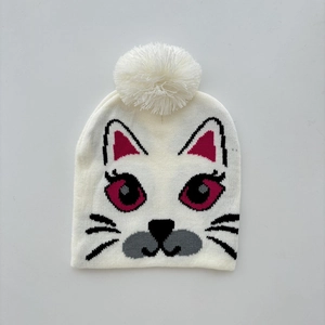 Detailed knit texture of white cat beanie with large pom-pom and cute embroidery