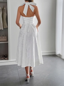 Dettaglio dell'abito bianco all'americana senza schienale con lacci e trama in jacquard