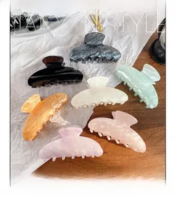 Collection of seven colorful marble acrylic hair claws for women in various trendy shades