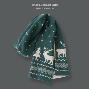 Green Christmas knit scarf with white deer pattern on a dark grey background