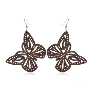 Detailed view of dark brown wooden butterfly earrings with silver hooks on white background