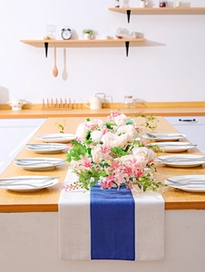 Detail of beige and royal blue cotton linen table runner with artificial floral decor