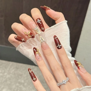 Unghie finte a mandorla bordeaux e nude con foglie d'oro e scintillanti cristalli di zircone