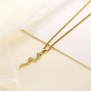 Gold snake pendant necklace with pavé cubic zirconia and green gem eyes for women