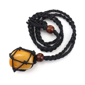Detail of a natural yellow raw stone pendant secured in a black woven mesh cord necklace