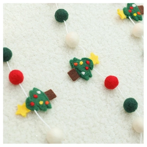 Detailed view of handmade wool felt Christmas tree ornaments with colorful felt balls