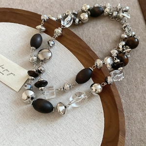 Detail of vintage layered wood bead necklace with crystal accents and cross pendant