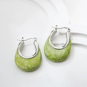 Macro shot of U-shaped silver hoop earrings with light green marbled enamel inlay