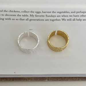 Detail of adjustable S925 silver rings with hammered texture on an open book
